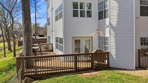 A two-story residential building with a deck, a covered patio, and a visible garage. - Lakefront walk-in condo overlooking Marina (Branson)
