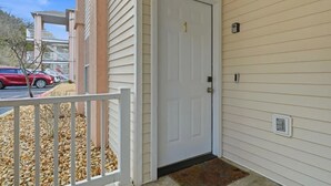 A white door with a number 1, a white picket fence, and a small step leading to a porch. - Lakefront walk-in condo overlooking Marina (Branson)