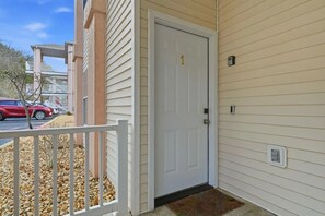 A white door with a number 1, a white picket fence, and a small step leading to a porch. - Lakefront walk-in condo overlooking Marina (Branson)