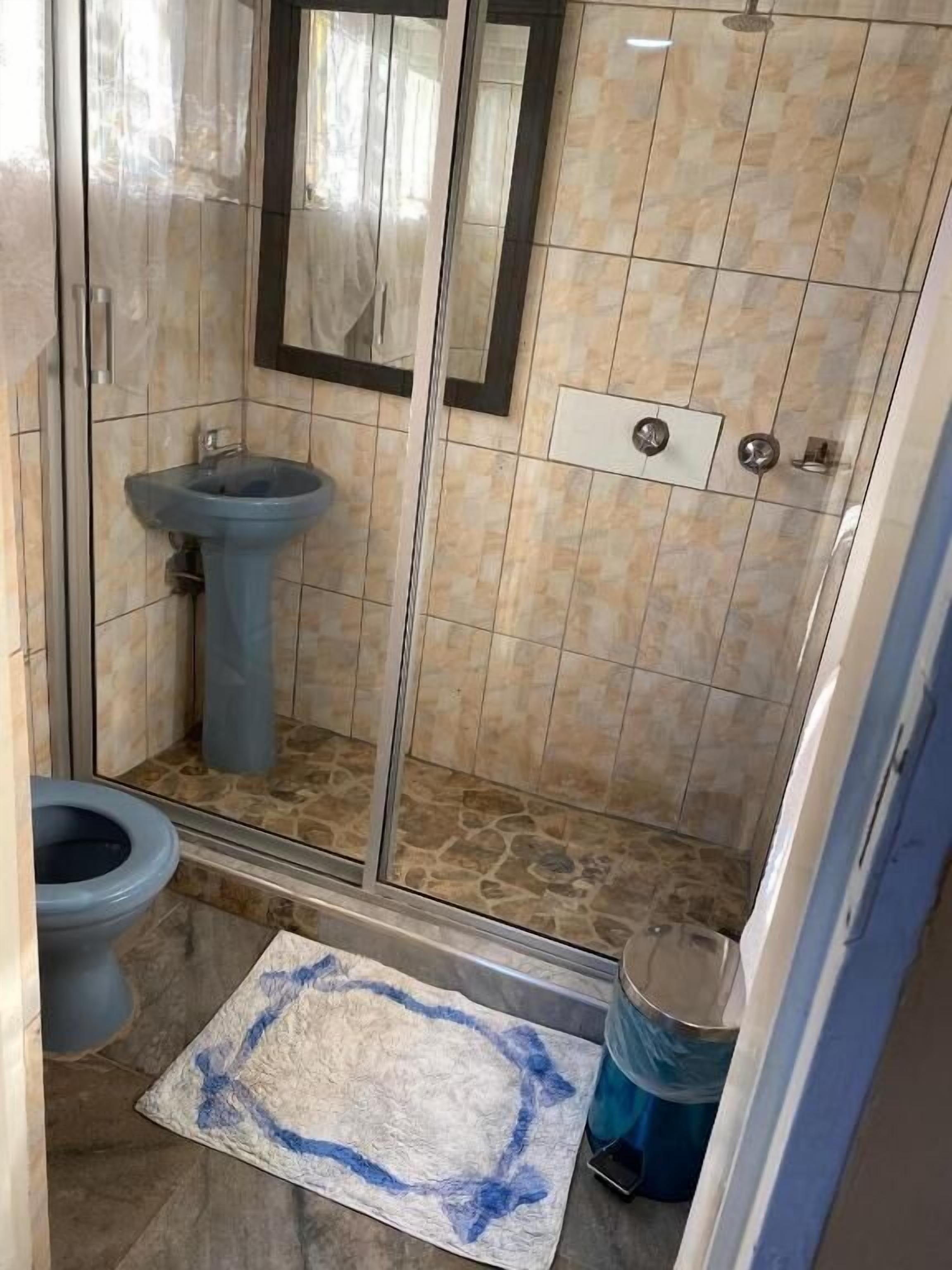 A bathroom with a shower, sink, and toilet.