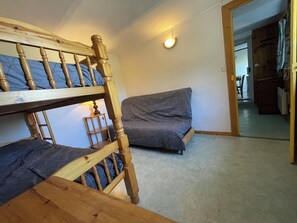 Ein Zimmer mit Etagenbetten, einer Couch und einem kleinen Tisch.