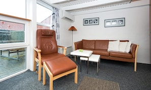 A modern living room with a leather armchair, a brown leather sofa, a white coffee table, and a floor lamp. - Bork Harbor: Ringkobing Fjord (Hemmet)