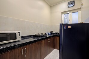 Eine Küche mit Mikrowelle, Herd, Kühlschrank und Schränken.