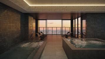 A spa room with a city view, two hot tubs, and lounge chairs.
