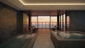 A spa room with a city view, two hot tubs, and lounge chairs.