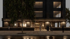 A modern building with a ground-level bar area, large windows, and a tree in front.