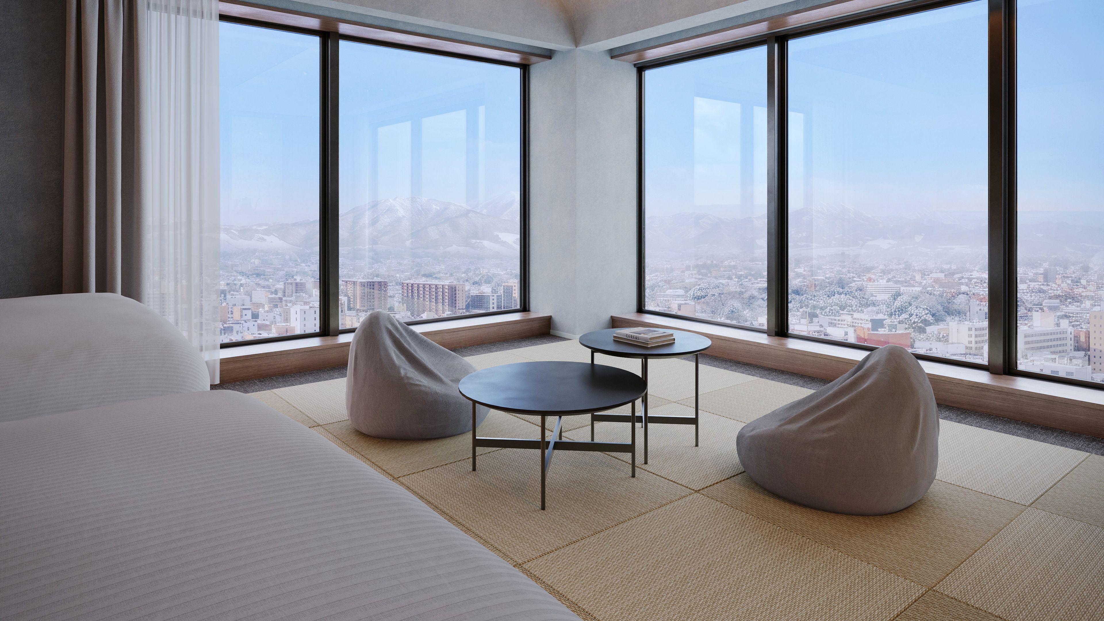 Une chambre d’hôtel moderne avec un grand lit, une petite table ronde, deux fauteuils en forme de poire et une vue sur le paysage urbain à travers de grandes fenêtres.