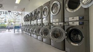 En række industrielle vaskemaskiner i et offentligt vaskeri.