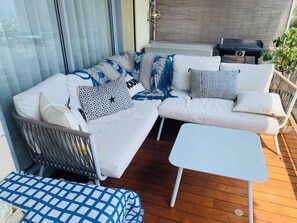 A modern outdoor seating area with a white sofa, patterned cushions, a small white table, and a wicker chair. - Elegance, comfort, and a sweeping view (Villefranche-sur-Mer)