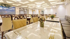 A spacious dining area with high ceilings, recessed lighting, and a central table with floral centerpieces. - Palette Hotel Cecil Srinagar (Srinagar)