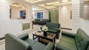 A modern lobby with a reception desk, green seating area, and a decorative wall. - Palette Hotel Cecil Srinagar (Srinagar)