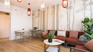 Una sala de estar moderna con sofá, mesa de centro y comedor.