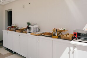 Un'area buffet con diversi cibi e una macchina da caffè.