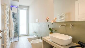 A modern bathroom with a freestanding bathtub, a bidet, and a toilet.