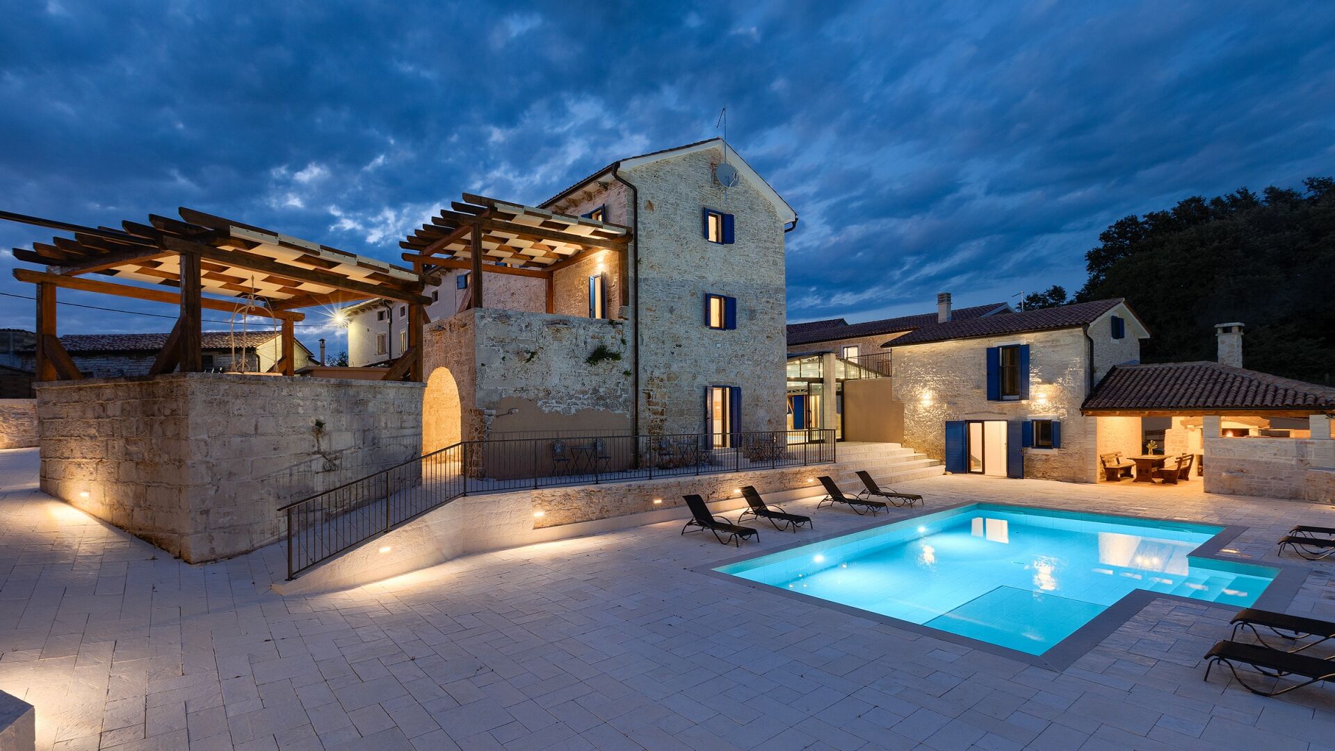 A stone building with a pool and outdoor seating.