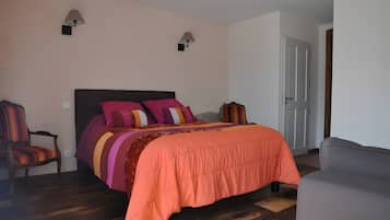 A bedroom with a bed, two wall-mounted lamps, a chair, and a door.