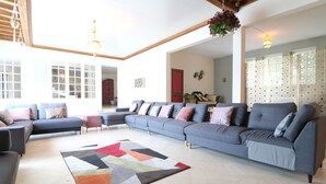 A spacious living area with a large sectional sofa, a colorful rug, and a wooden ceiling. - Villa 'Alhambra' with Private Terrace, Wi-Fi and Air Conditioning (Vierzon)