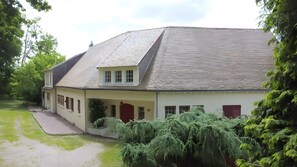A two-story house with a sloped roof, a covered porch, and a well-maintained lawn.