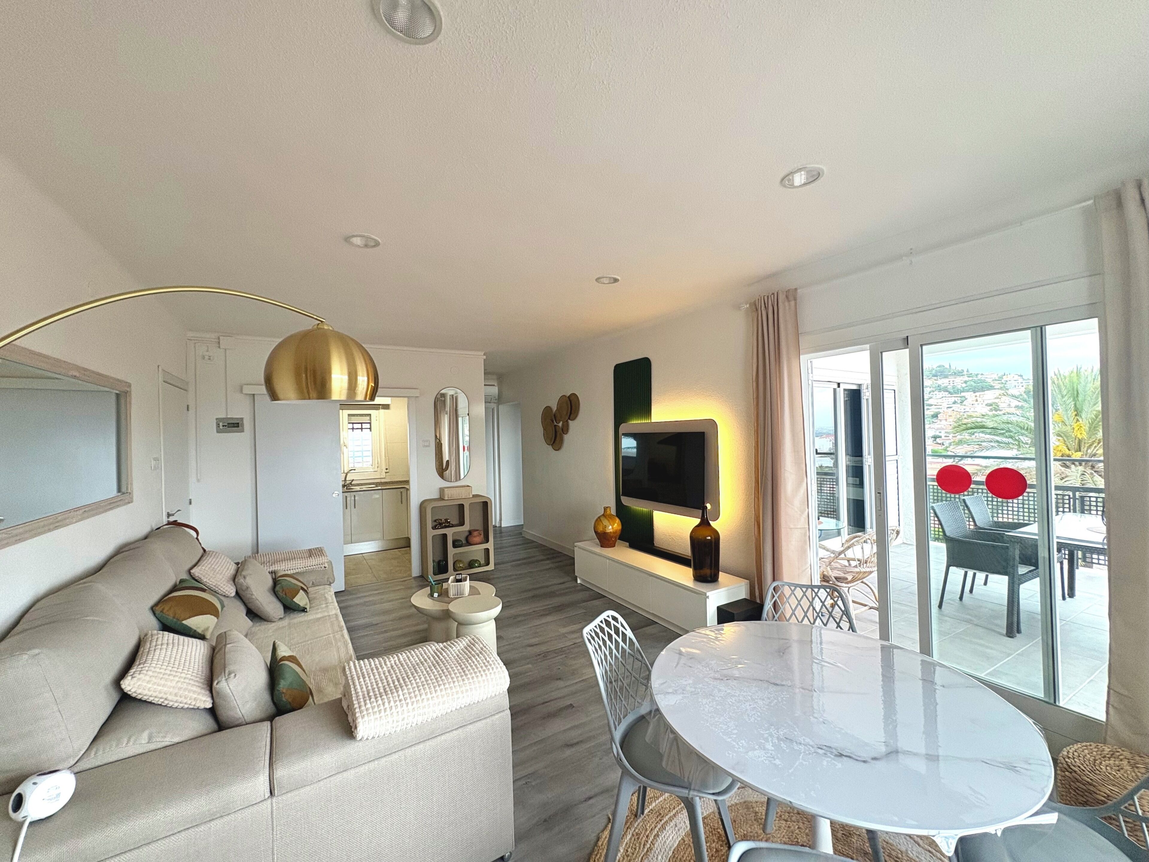 A modern living room with a sofa, a round table, and a TV.