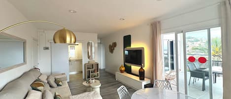 A modern living room with a sofa, a round table, and a TV.