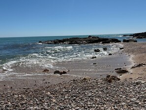 A rocky beach with waves, pebbles, and a clear sky. - Oasis with panoramic views of the Mediterranean, a pool, and private parking (Peñiscola)