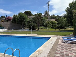 A swimming pool with a tiled edge, a metal ladder, and a few lounge chairs. - Oasis with panoramic views of the Mediterranean, a pool, and private parking (Peñiscola)