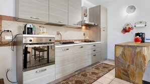 Una cocina moderna con horno integrado, estufa a gas y una cafetera.
