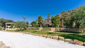 A coastal property with a stone wall, a grassy area, and a building with a tiled roof. - Guesthouse 'Casita Chupito' with Mountain Views, Wi-Fi and Air Conditioning (Alozaina)