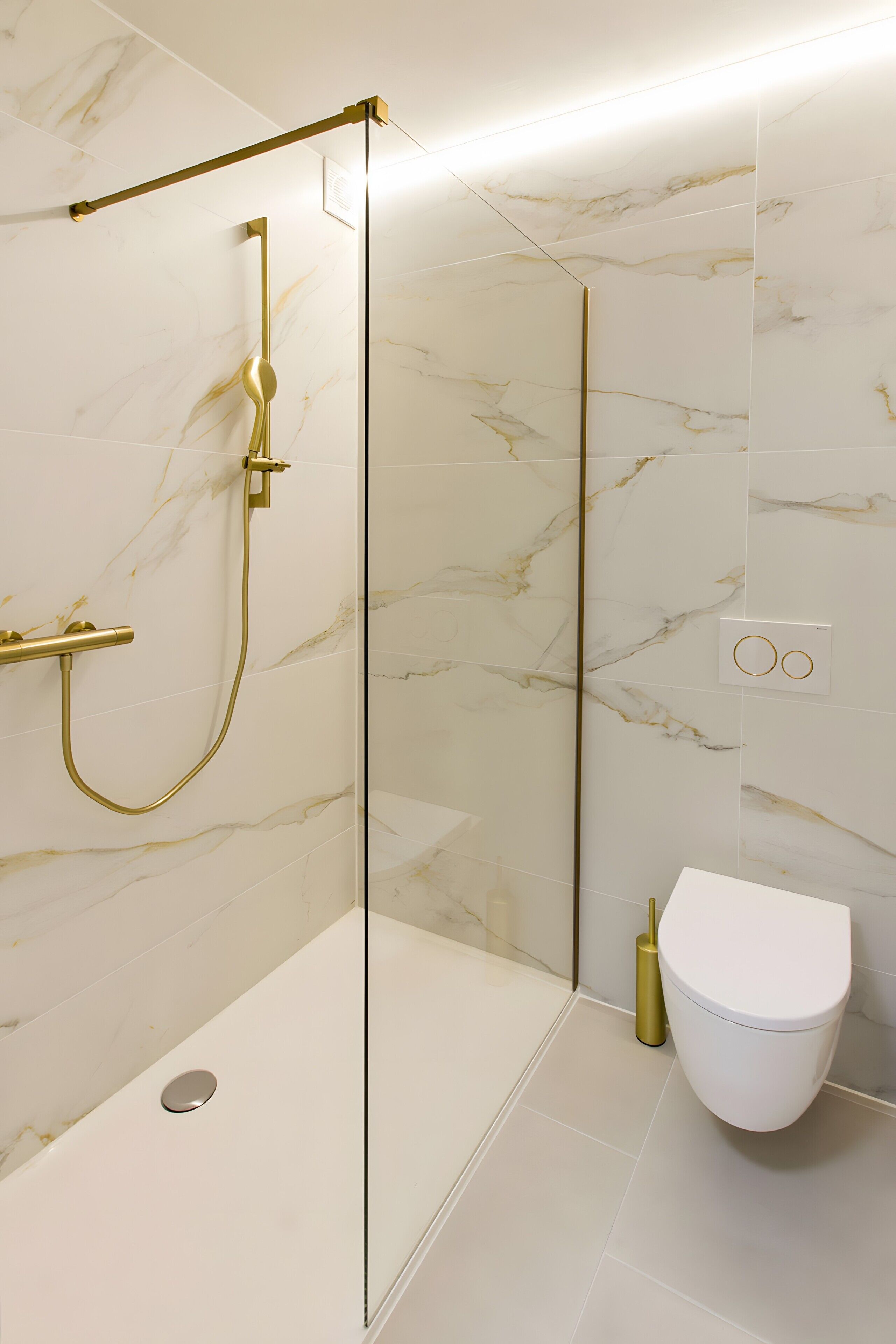 Ein modernes Badezimmer mit einer gläsernen Duschkabine, einer weißen Toilette und Wänden mit Marmoroptik.