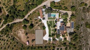 An aerial view of a residential property with a swimming pool, solar panels, and a fenced area. - Guesthouse 'Casita Chupito' with Mountain Views, Wi-Fi and Air Conditioning (Alozaina)