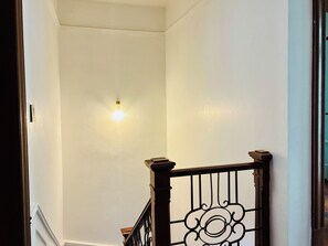 A staircase with a wooden handrail and a light fixture on the wall. - Chic 3-bedroom townhouse in heart of Roma Norte (Ciudad de México)