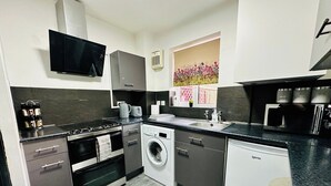 A compact kitchen with a stove, oven, microwave, and dishwasher. - Hockley 4-bed, Sleeps 13 w/ Garden & Free Parking (Birmingham)