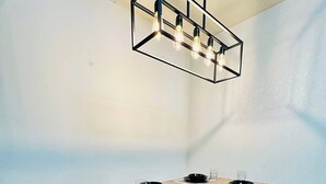 A dining area with a wooden table, black chairs, and a hanging light fixture. - Hockley 4-bed, Sleeps 13 w/ Garden & Free Parking (Birmingham)