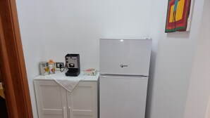 A kitchen with a white refrigerator, a coffee machine, and a small countertop with various items. - Villa Giusy: Pool and Relaxation in Salento (Galatina)