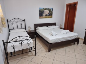 Una camera da letto con un letto matrimoniale, un comodino, una lampada e un quadro appeso al muro.