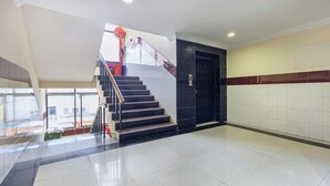 A staircase with a handrail, a door, and a tiled floor. - SRINIVASA RESIDENCY (Tirupati)