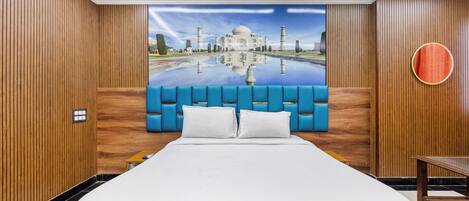 A hotel room with a large bed, a ceiling fan, and a wall mural of a famous monument.