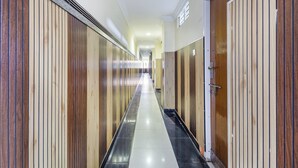 A long, narrow hallway with wooden paneling on the walls and a tiled floor. - SRINIVASA RESIDENCY (Tirupati)