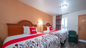 Une chambre d’hôtel avec deux lits, une chaise, une fenêtre avec des rideaux et une porte.