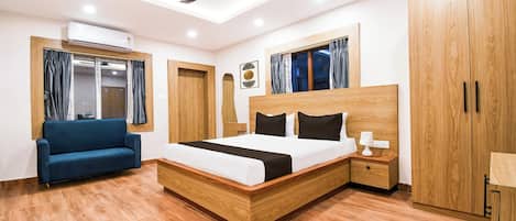 A modern bedroom with a bed, a ceiling fan, a sofa, and wooden wardrobes.
