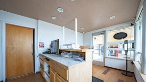 A modern kitchen with wooden cabinets, a marble countertop, and a built-in oven.