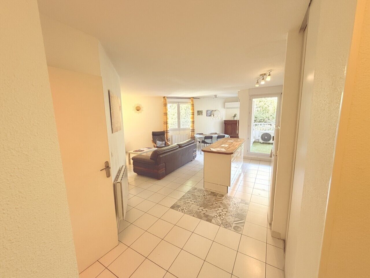 A spacious living area with a sofa, a coffee table, and a dining table.