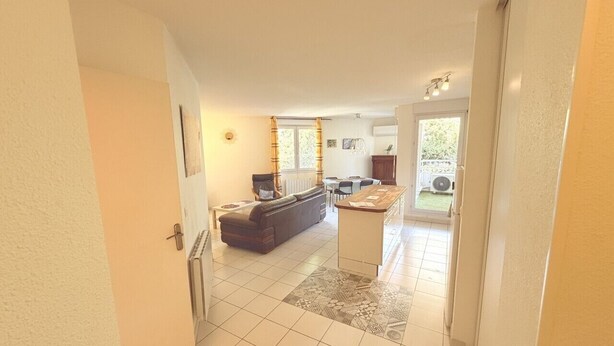 A spacious living area with a sofa, a coffee table, and a dining table. - Montpellier Sunlight, Air Conditioning, Pool, and Private Parking (Montpellier)