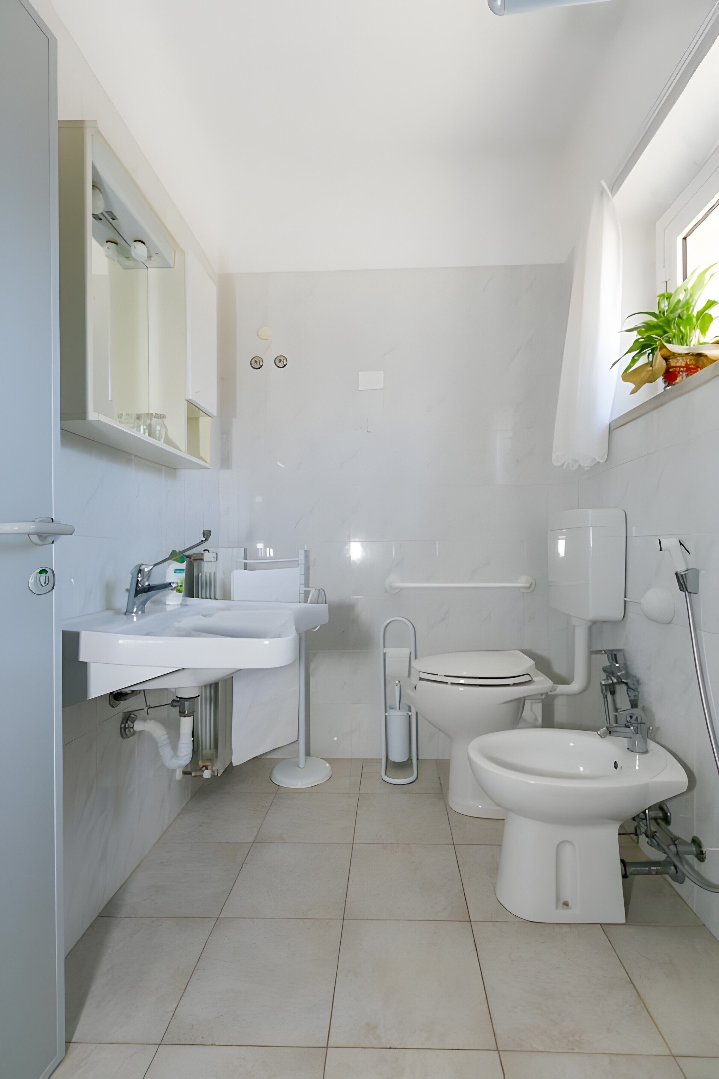 A modern bathroom with a toilet, bidet, and sink.