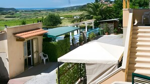 Eine Dachterrasse mit Blick auf einen Swimmingpool, eine Pergola und ein Blumentopf mit Blumen.
