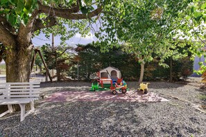 A park with a playhouse, a bench, and a stroller. - Apartment 'Agriturismo Case Nuove - Girasole' with Shared Pool, Wi-Fi and Air Conditioning (Castellina Marittima)