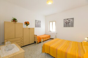 A bedroom with a bed, a wardrobe, a desk, and a window. - Apartment 'Agriturismo Case Nuove - Geranio' with Shared Pool, Wi-Fi and Air Conditioning (Castellina Marittima)