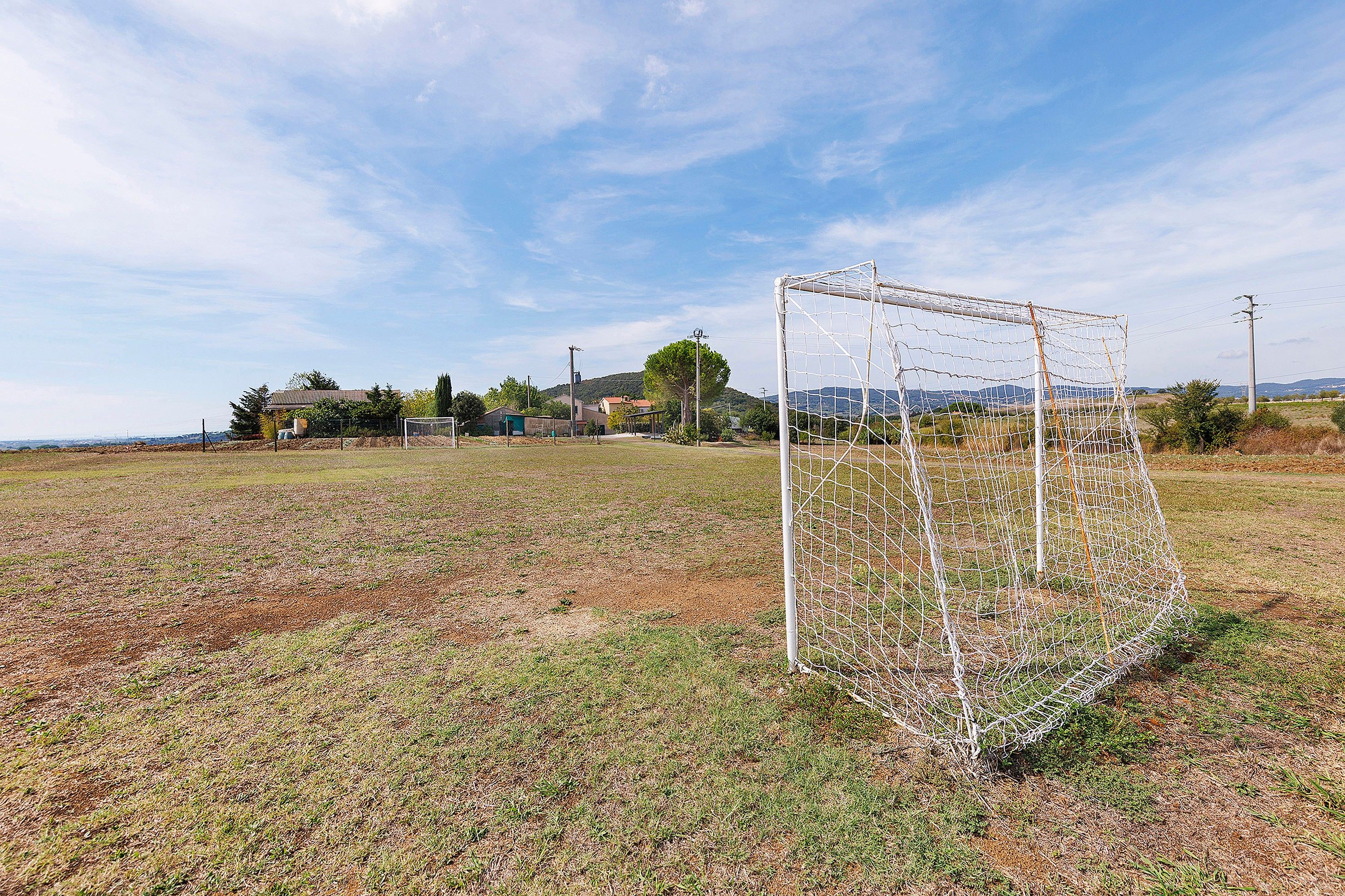 A soccer goal in a field with a clear sky.
