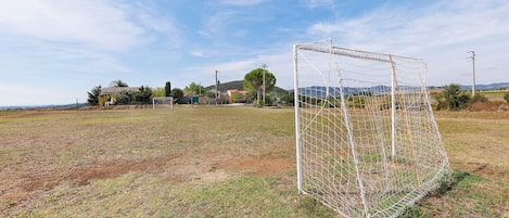 A soccer goal in a field with a clear sky.