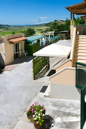 Eine Dachterrasse mit Blick auf einen Swimmingpool, eine Pergola und ein Blumentopf mit Blumen.